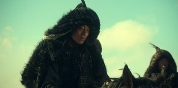 Movie still from “Kingdom: Ashin of the North” (2021), directed by Kim Seong-hun – A man wearing a black fur coat and a black hat; Close Up shot, Low angle