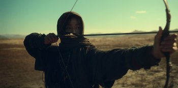 Movie still from “Kingdom: Ashin of the North” (2021), directed by Kim Seong-hun – A man holding a bow and arrow in the desert; Medium shot, Low angle