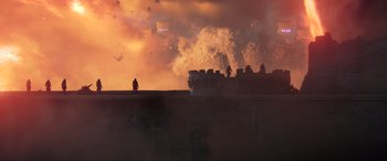 Movie still from “Kingsglaive: Final Fantasy XV” (2016), directed by Takeshi Nozue – A person standing in front of a building with smoke coming out of it; Extreme Wide shot, Low angle