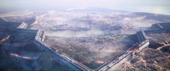 Movie still from “Kingsglaive: Final Fantasy XV” (2016), directed by Takeshi Nozue – An aerial view of a large city with fog rolling in the background; Extreme Wide shot, High angle