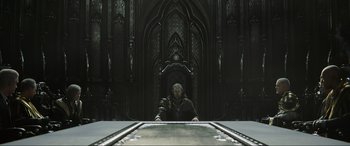 Movie still from “Kingsglaive: Final Fantasy XV” (2016), directed by Takeshi Nozue – A man standing in front of an empty table in a dark room; Wide shot, Low angle