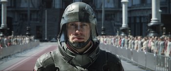 Movie still from “Kingsglaive: Final Fantasy XV” (2016), directed by Takeshi Nozue – A man wearing a helmet is standing in front of a crowd of onlookers; Close Up shot, Over the shoulder angle