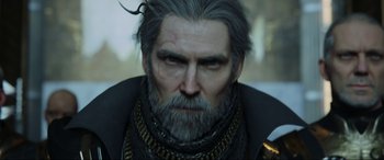 Movie still from “Kingsglaive: Final Fantasy XV” (2016), directed by Takeshi Nozue – An old man with a beard and a chain around his neck; Close Up shot, Over the shoulder angle
