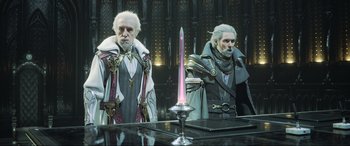 Movie still from “Kingsglaive: Final Fantasy XV” (2016), directed by Takeshi Nozue – A couple of men standing next to each other in a room; Medium shot, Over the shoulder angle
