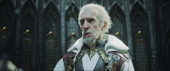 Movie still from “Kingsglaive: Final Fantasy XV” (2016), directed by Takeshi Nozue – An old man with white hair and a white beard; Close Up shot, Over the shoulder angle