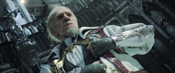 Movie still from “Kingsglaive: Final Fantasy XV” (2016), directed by Takeshi Nozue – An old man wearing a suit of armor and holding a sword; Close Up shot, Low angle