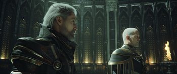 Movie still from “Kingsglaive: Final Fantasy XV” (2016), directed by Takeshi Nozue – A man with a beard and a white beard is standing next to a man with white hair; Medium shot, Low angle