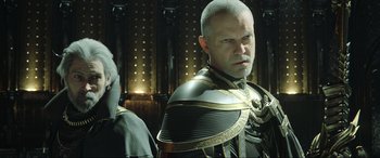 Movie still from “Kingsglaive: Final Fantasy XV” (2016), directed by Takeshi Nozue – A man in a black and gold outfit and a man in a black and gold outfit; Close Up shot, Over the shoulder angle