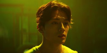 Movie still from “Knights of the Zodiac” (2023), directed by Tomasz Baginski – A young man with short brown hair is looking at the camera; Close Up shot, Low angle