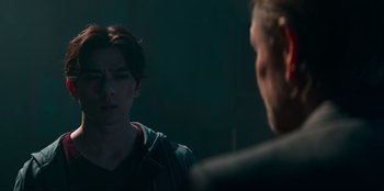 Movie still from “Knights of the Zodiac” (2023), directed by Tomasz Baginski – A man and a woman are talking in a dark room; Close Up shot, Over the shoulder angle