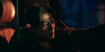 Movie still from “Knights of the Zodiac” (2023), directed by Tomasz Baginski – A young man is sitting in a dark room; Close Up shot, Over the shoulder angle