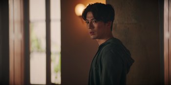 Movie still from “Knights of the Zodiac” (2023), directed by Tomasz Baginski – A man standing in front of a window; Close Up shot, Over the shoulder angle