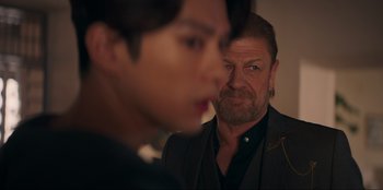 Movie still from “Knights of the Zodiac” (2023), directed by Tomasz Baginski – A person looking at a man in a mirror; Close Up shot, Over the shoulder angle