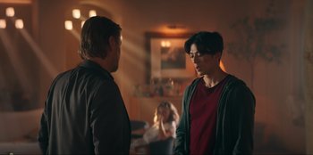 Movie still from “Knights of the Zodiac” (2023), directed by Tomasz Baginski – Two men are talking in a living room; Medium shot, Over the shoulder angle