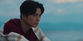 Movie still from “Knights of the Zodiac” (2023), directed by Tomasz Baginski – A person with a towel around his neck; Close Up shot, Over the shoulder angle