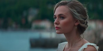 Movie still from “Knights of the Zodiac” (2023), directed by Tomasz Baginski – A beautiful young lady looking off into the distance; Close Up shot, Over the shoulder angle