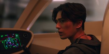 Movie still from “Knights of the Zodiac” (2023), directed by Tomasz Baginski – A young man with red makeup on his face looking into the distance; Close Up shot, Low angle