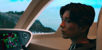 Movie still from “Knights of the Zodiac” (2023), directed by Tomasz Baginski – A young man sitting in the driver's seat of a car; Close Up shot, Low angle