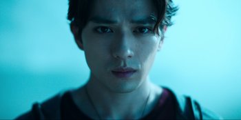 Movie still from “Knights of the Zodiac” (2023), directed by Tomasz Baginski – A man's face in a blue light; Close Up shot, Low angle