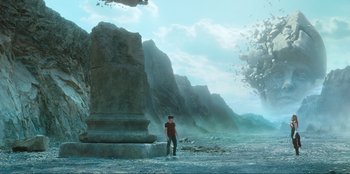 Movie still from “Knights of the Zodiac” (2023), directed by Tomasz Baginski – A man standing in front of a large rock formation; Extreme Wide shot, Low angle