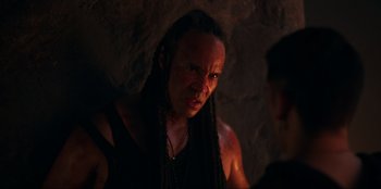Movie still from “Knights of the Zodiac” (2023), directed by Tomasz Baginski – A man with dreadlocks is looking at the camera; Close Up shot, Over the shoulder angle