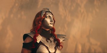 Movie still from “Knights of the Zodiac” (2023), directed by Tomasz Baginski – A woman with red hair wearing a silver armor; Medium shot, Low angle