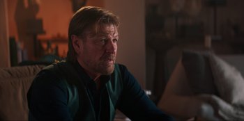 Movie still from “Knights of the Zodiac” (2023), directed by Tomasz Baginski – A person sitting in a room; Close Up shot, Over the shoulder angle