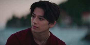 Movie still from “Knights of the Zodiac” (2023), directed by Tomasz Baginski – A person wearing a red shirt; Close Up shot, Over the shoulder angle