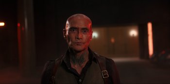 Movie still from “Knights of the Zodiac” (2023), directed by Tomasz Baginski – A man with a tattoo on his head and neck; Close Up shot, Low angle