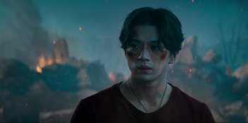 Movie still from “Knights of the Zodiac” (2023), directed by Tomasz Baginski – A young man is looking into the distance; Close Up shot, Over the shoulder angle