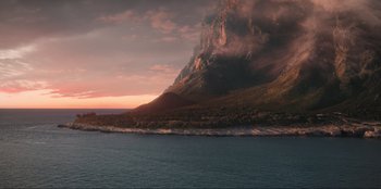 Movie still from “Knights of the Zodiac” (2023), directed by Tomasz Baginski – A view of a body of water with a mountain in the background; Extreme Wide shot, High angle