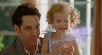 Movie still from “Knocked Up” (2007), directed by Judd Apatow – A man and a little girl are smiling for the camera; Close Up shot, Over the shoulder angle