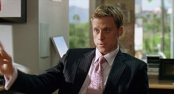 Movie still from “Knocked Up” (2007), directed by Judd Apatow – A man in a suit and tie sitting in a chair; Close Up shot, Over the shoulder angle