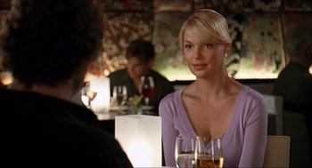 Movie still from “Knocked Up” (2007), directed by Judd Apatow – A woman sitting at a table with a glass of wine; Medium shot, Over the shoulder angle
