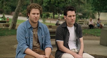Movie still from “Knocked Up” (2007), directed by Judd Apatow – Two men sitting next to each other on a bench; Medium shot, High angle