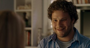 Movie still from “Knocked Up” (2007), directed by Judd Apatow – A person with curly hair smiling; Close Up shot, Over the shoulder angle