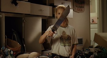 Movie still from “Knocked Up” (2007), directed by Judd Apatow – A woman holding a large knife in a kitchen; Medium shot, Low angle
