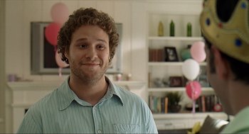 Movie still from “Knocked Up” (2007), directed by Judd Apatow – A man with curly brown hair standing in a living room; Close Up shot, Over the shoulder angle