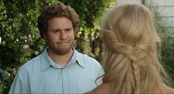 Movie still from “Knocked Up” (2007), directed by Judd Apatow – A man with curly hair and a blue striped shirt is talking to a blonde woman; Close Up shot, Over the shoulder angle