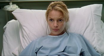 Movie still from “Knocked Up” (2007), directed by Judd Apatow – A woman laying in a hospital bed looking at the camera; Close Up shot, Low angle