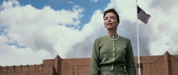 Movie still from “Knowing” (2009), directed by Alex Proyas – A woman standing in front of a brick building; Medium shot, Low angle
