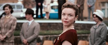 Movie still from “Knowing” (2009), directed by Alex Proyas – An older woman wearing a dress and pearl necklace; Close Up shot, Low angle