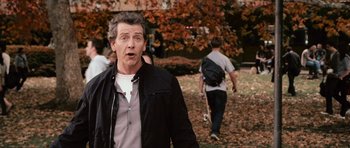 Movie still from “Knowing” (2009), directed by Alex Proyas – A man standing in the grass with a skateboard; Medium shot, Over the shoulder angle