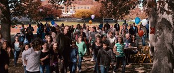 Movie still from “Knowing” (2009), directed by Alex Proyas – A group of people standing in a field with balloons; Wide shot, High angle