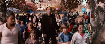 Movie still from “Knowing” (2009), directed by Alex Proyas – A man standing in front of a group of people; Wide shot, Over the shoulder angle