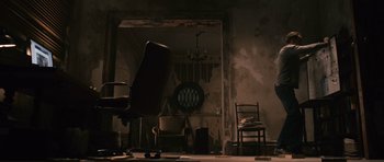 Movie still from “Knowing” (2009), directed by Alex Proyas – A chair and a chair in a room; Wide shot, High angle