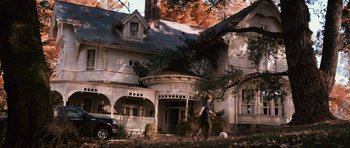 Movie still from “Knowing” (2009), directed by Alex Proyas – A man walking in front of a house with a soccer ball; Wide shot, Low angle
