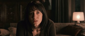 Movie still from “Knowing” (2009), directed by Alex Proyas – A person sitting on a couch; Close Up shot, High angle