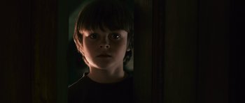 Movie still from “Knowing” (2009), directed by Alex Proyas – A young boy is staring at the camera; Close Up shot, Low angle