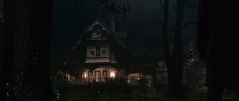 Movie still from “Knowing” (2009), directed by Alex Proyas – A house that is lit up at night time; Extreme Wide shot, Low angle